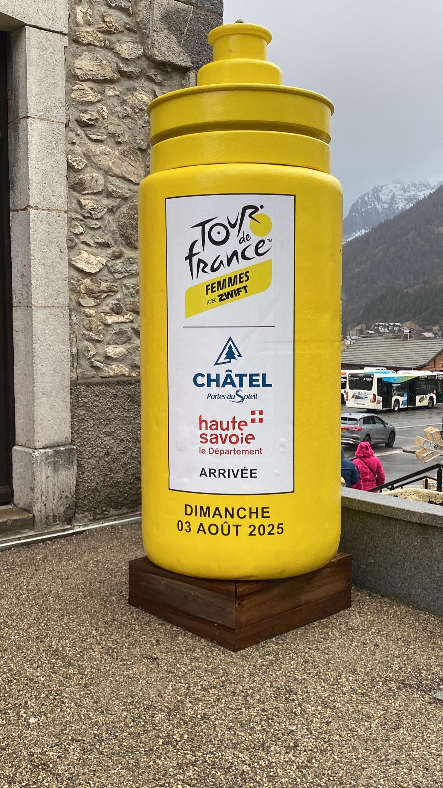 Gelber Tour de France-Gewinnerpokal mit Informationen zur Ankunft am 3. August 2025 in Châtel, Haut-Savoie.