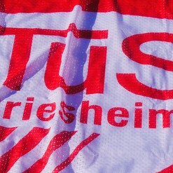 Rot-weißes Sportbanner mit dem Schriftzug "TuS Griesheim" in prägnanter Schriftart.