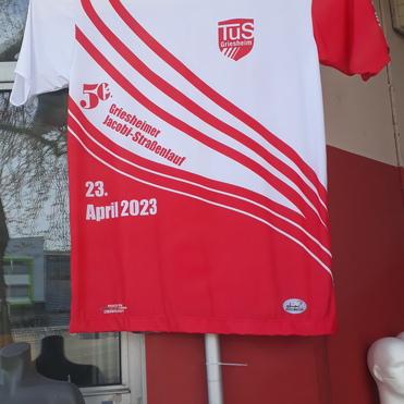 T-Shirt mit rot-weißen Design und Aufdruck für den Griesheimer Jacobi-Straßenlauf, datiert auf den 23. April 2023.