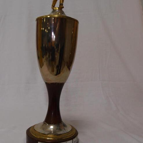 Goldfarbener Pokal mit einer Figur auf dem Deckel, beschriftet mit „Clubmeister des SKC Griesheim“.