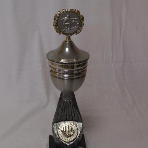 Silberner Pokal auf schwarzem Sockel mit Inschrift „2. Platz KVD-VMM“ und Kranz-Emblem oben.
