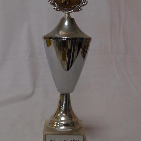 Silberner Pokal mit bronzener Medaille und Beschriftung „Hufeisen Pokal 1987 SKV Pfungstadt 1. Platz“.