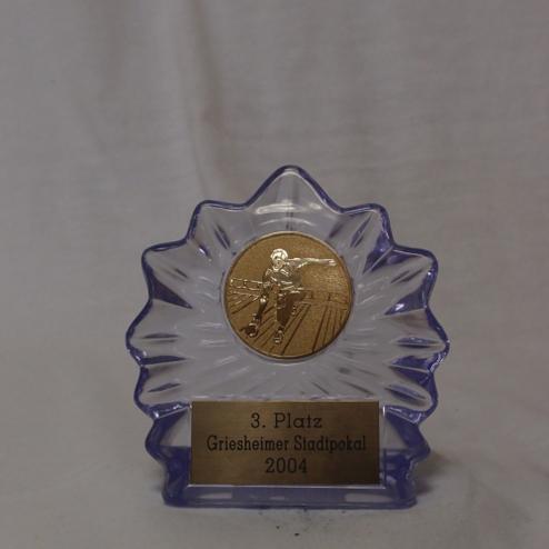 Dreieckiger Pokal mit goldener Medaille und gravierter Plakette: „3. Platz, Griesheimer Stadtpokal 2004“.