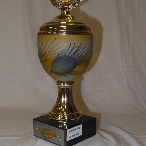 Pokale mit goldener Oberfläche und einem dekorativen oberen Teil, auf einem schwarzen Sockel mit Inschrift.