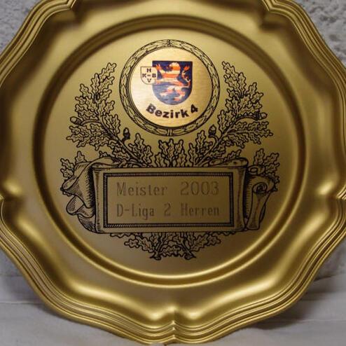 Goldener Meistertitel von 2003, D-Liga 2 Herren, mit Vereinswappen und floralem Randmotiv.