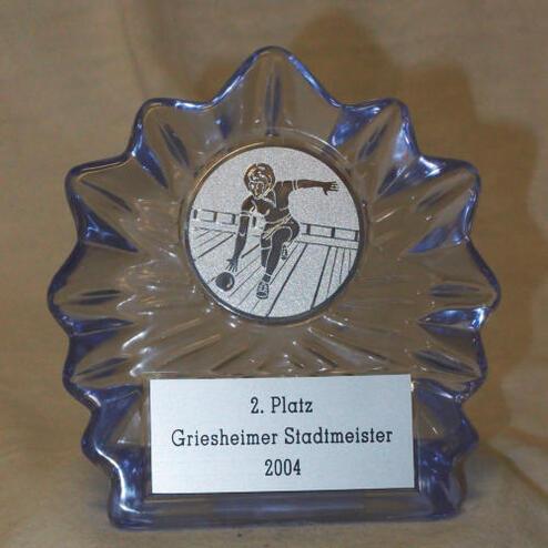 Glas-Trophäe mit Gravur „2. Platz Griesheimer Stadtmeister 2004“ und Abbildung eines Sportlers auf einer Bahn.