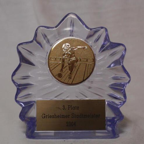 Dreieinhalb-eckige Trophäe mit bronzener Medaille und Gravur „3. Platz Griesheimer Stadtmeister 2004“.