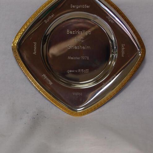 Gravierte, dreieckige Silberplakette mit goldenen Kanten, Meistertitel „Bezirksliga Griesheim 1978“ und Namen.