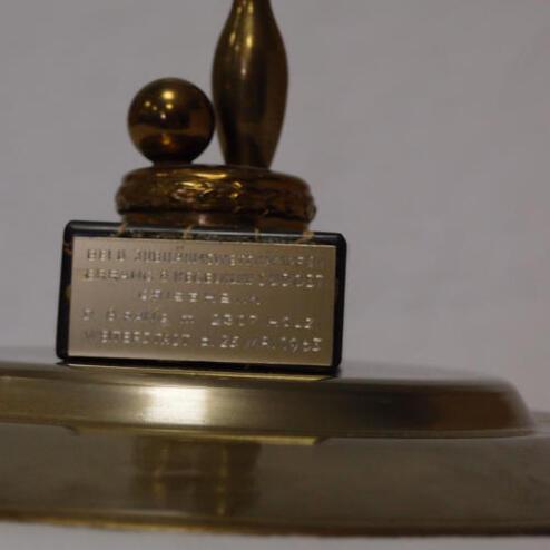 Goldfarbener Pokal mit einer Bowling-Kugel und einem Kegel, versehen mit einer gravierten Plakette.