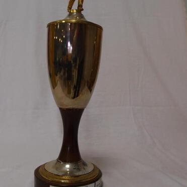 Goldfarbener Pokal mit einer Figur auf dem Deckel, beschriftet mit „Clubmeister des SKC Griesheim“.