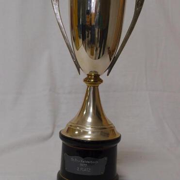 Silberner Pokal auf schwarzem Sockel mit gravierter Plakette „2. PLATZ“ in glänzender Metallfarbe.