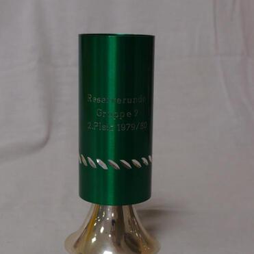 Grüner Pokal mit silbernem Fuß, graviert mit „Reserverunde Gruppe 2, 2. Platz 1979/80“.
