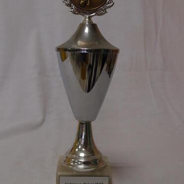 Silberner Pokal mit bronzener Medaille und Beschriftung „Hufeisen Pokal 1987 SKV Pfungstadt 1. Platz“.