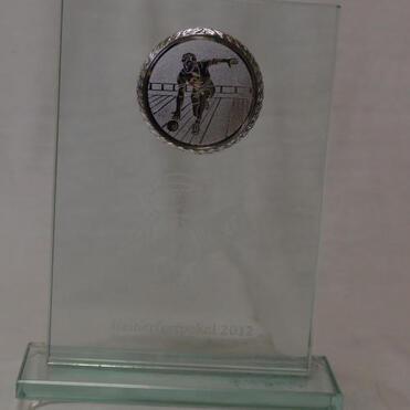 Glasplakette mit Metallmedaille und gravierter Inschrift „Hänufert-Pokal 2012“, gestaltet mit sportlichem Motiv.