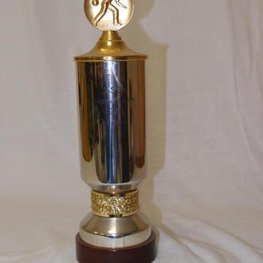 Glänzender Sporttrophy mit goldener Obenplatte und einer figurativen Darstellung eines Sportlers.