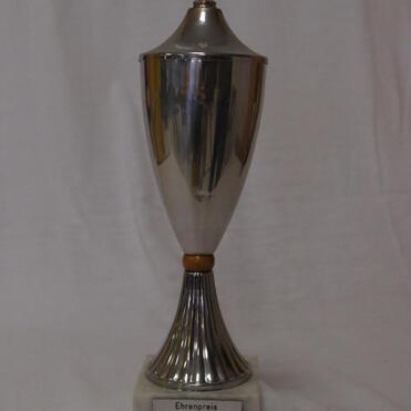 Silberner Pokal mit Deckel, auf Marmorsockel, beschriftet mit „Ehrenpreis HETZEL POKAL 1988“.