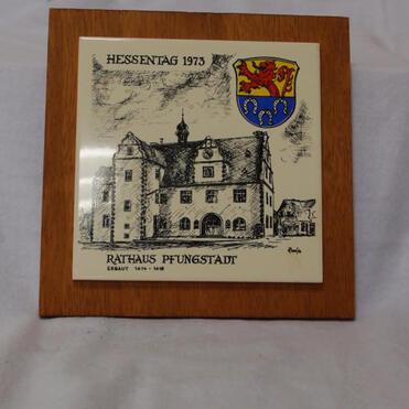 Illustration des Rathauses von Pfungstadt mit dem Wappen, umrahmt von einem Holzrahmen, datiert auf Hessentag 1973.
