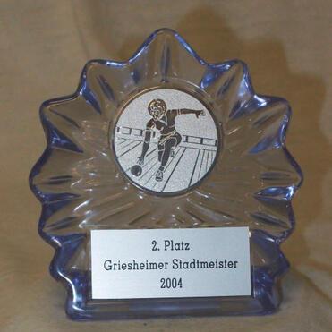 Glas-Trophäe mit Gravur „2. Platz Griesheimer Stadtmeister 2004“ und Abbildung eines Sportlers auf einer Bahn.