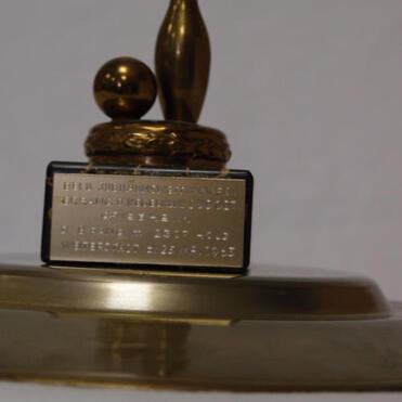 Goldfarbener Pokal mit einer Bowling-Kugel und einem Kegel, versehen mit einer gravierten Plakette.