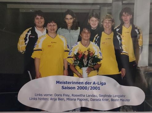 Gruppenfoto von sieben Sportlerinnen in gelben Trikots, eine hält Blumen, Titel: Meisterinnen der A-Liga Saison 2000/2001.