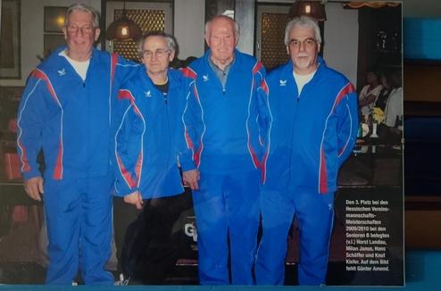 Vier Männer in blauen Sportanzügen posieren für ein Foto, das an ein Tischtennisturnier erinnert.