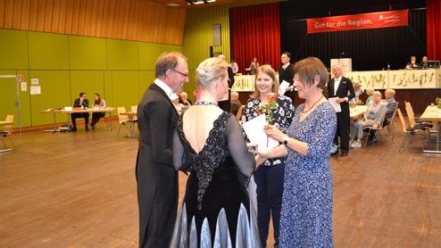 Verleihung von Urkunden in einer festlichen Veranstaltung mit Teilnehmern in eleganter Kleidung.