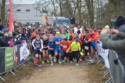 Start 5-km-Lauf Silvesterlauf 2025 Eine Gruppe an Läufer:innen die sich wie auf ein Startsignal nach vorne stürzen um den 5-km-Lauf zu bestreiten.
