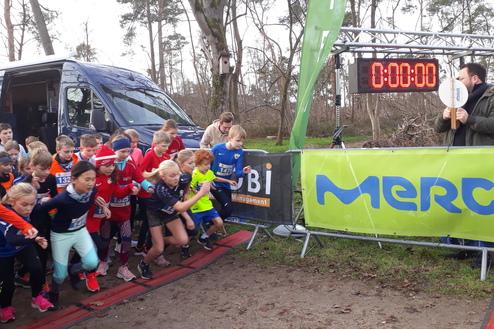 Gruppenauswahl von Kindern, die beim Laufstart über eine Startlinie sprinten, während ein Zähler auf null steht.