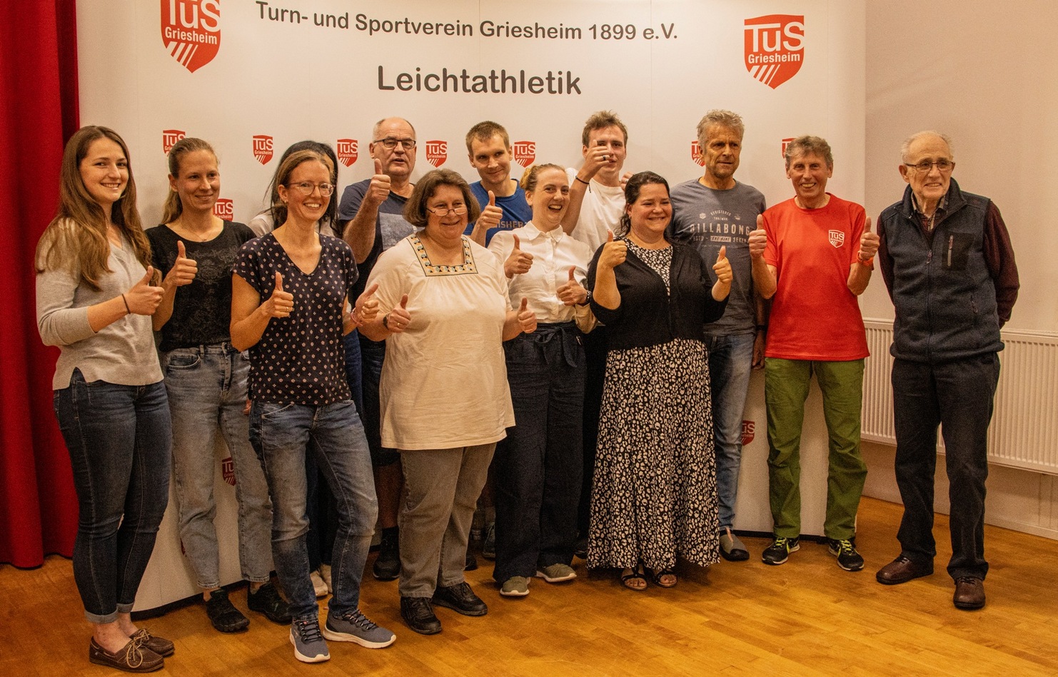 Gruppenzsammenkunft von Teilnehmern der Leichtathletikabteilung des TUS Griesheim, alle zeigen Daumen hoch.