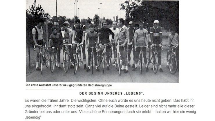 Gruppiert stehende Personen mit Fahrrädern auf einem Radweg, umgeben von Bäumen und einer Sportanlage.