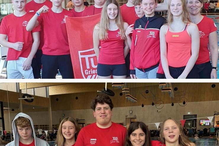 Gruppe von Schwimmern in roten T-Shirts posiert lächelnd vor einem Schwimmbecken in einer Sporthalle.