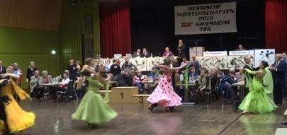 Tanzpaare in bunten Kleidern treten bei den Hessischen Meisterschaften 2015 auf einer B&uuml;hne vor Publikum auf.