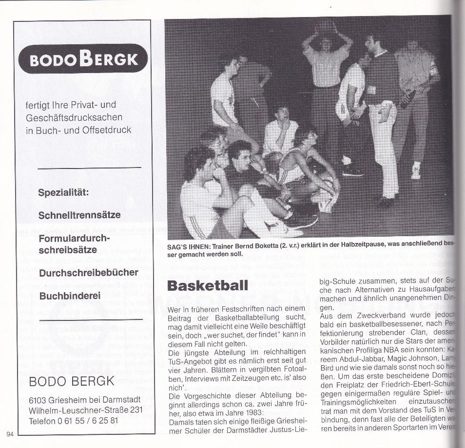 Gruppe von Basketballspielern und Trainer, die während einer Halbzeitpause auf dem Boden sitzen und diskutieren.