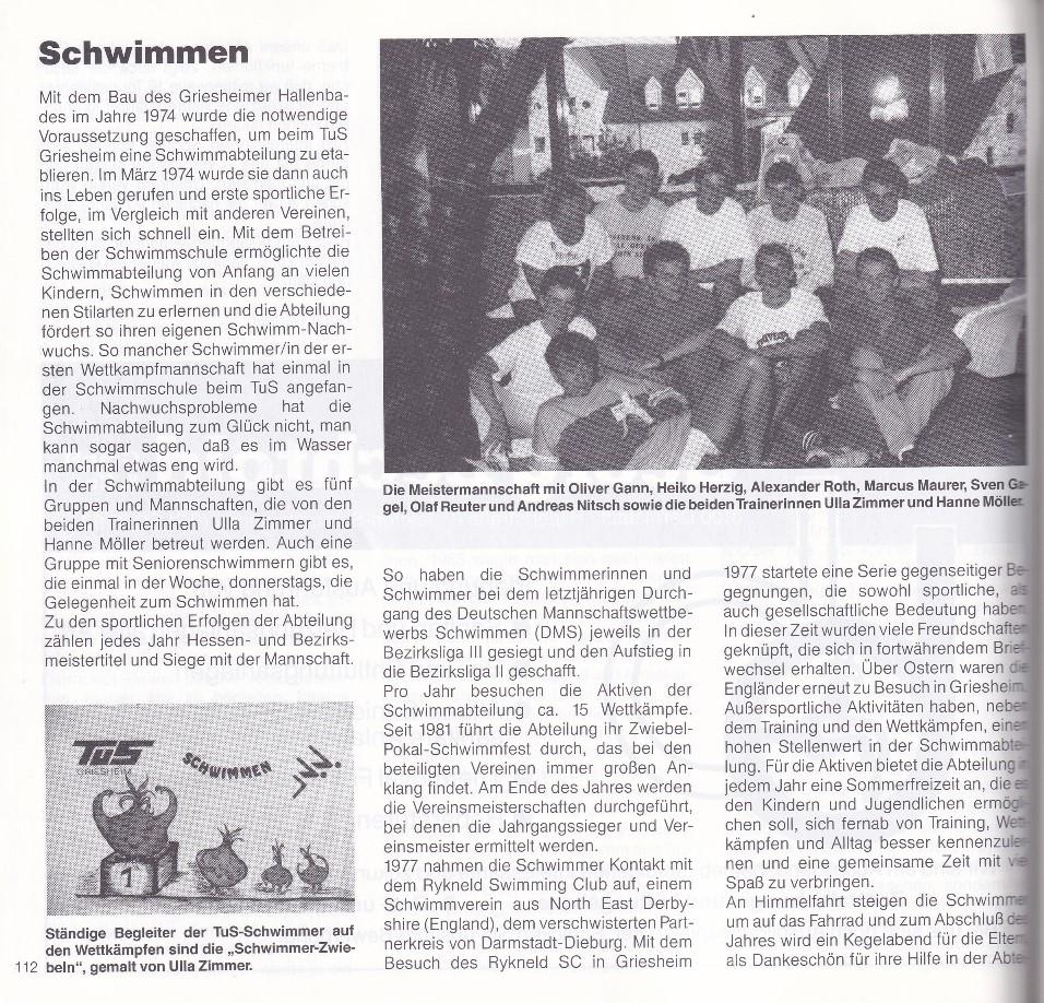 Gruppenfoto der Schwimmmeisterschaft mit Teilnehmern und Trainern in einem Veranstaltungsraum.