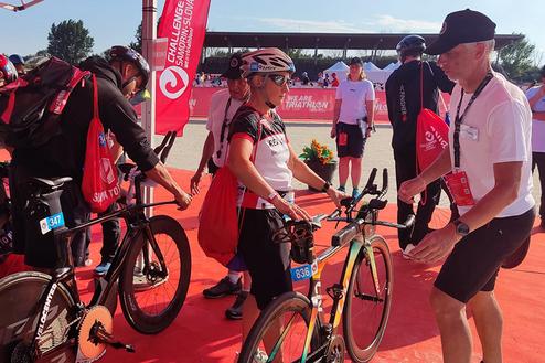 Teilnehmer bereiten sich auf den Triathlon vor, während sie ihre Fahrräder am Startpunkt aufstellen.