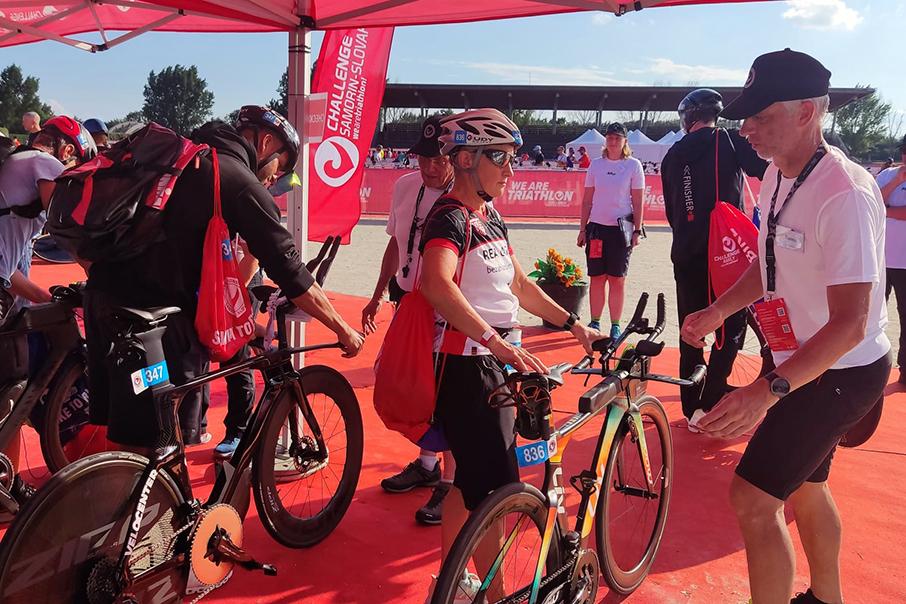 Teilnehmer bereiten sich auf den Triathlon vor, während sie ihre Fahrräder am Startpunkt aufstellen.