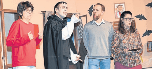 Vier Schauspieler in Kostümen auf einer Bühne, darunter ein Vampir, in einer skurrilen Theateraufführung.